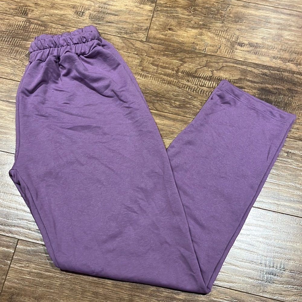 Purple sweatpants with elastic waistband.